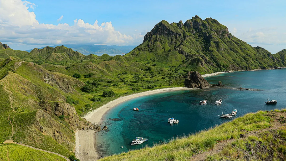Traditional wooden liveaboard boat on calm turquoise water, Komodo
